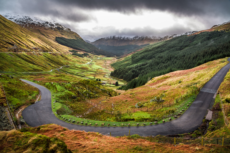 highland glen with road passing through it and mountains
